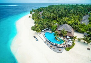 A resort with a large swimming pool, beach, and dense tropical vegetation. - Filitheyo Island Resort (Filitheyo)