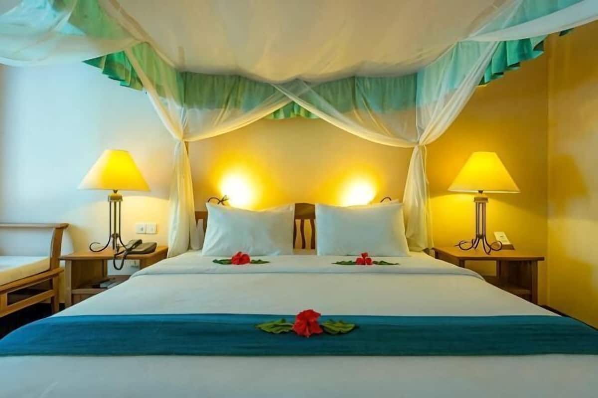 Ein Hotelzimmer mit einem Bett, zwei Nachttischlampen, einem Telefon am Nachttisch und einem Nachttisch.