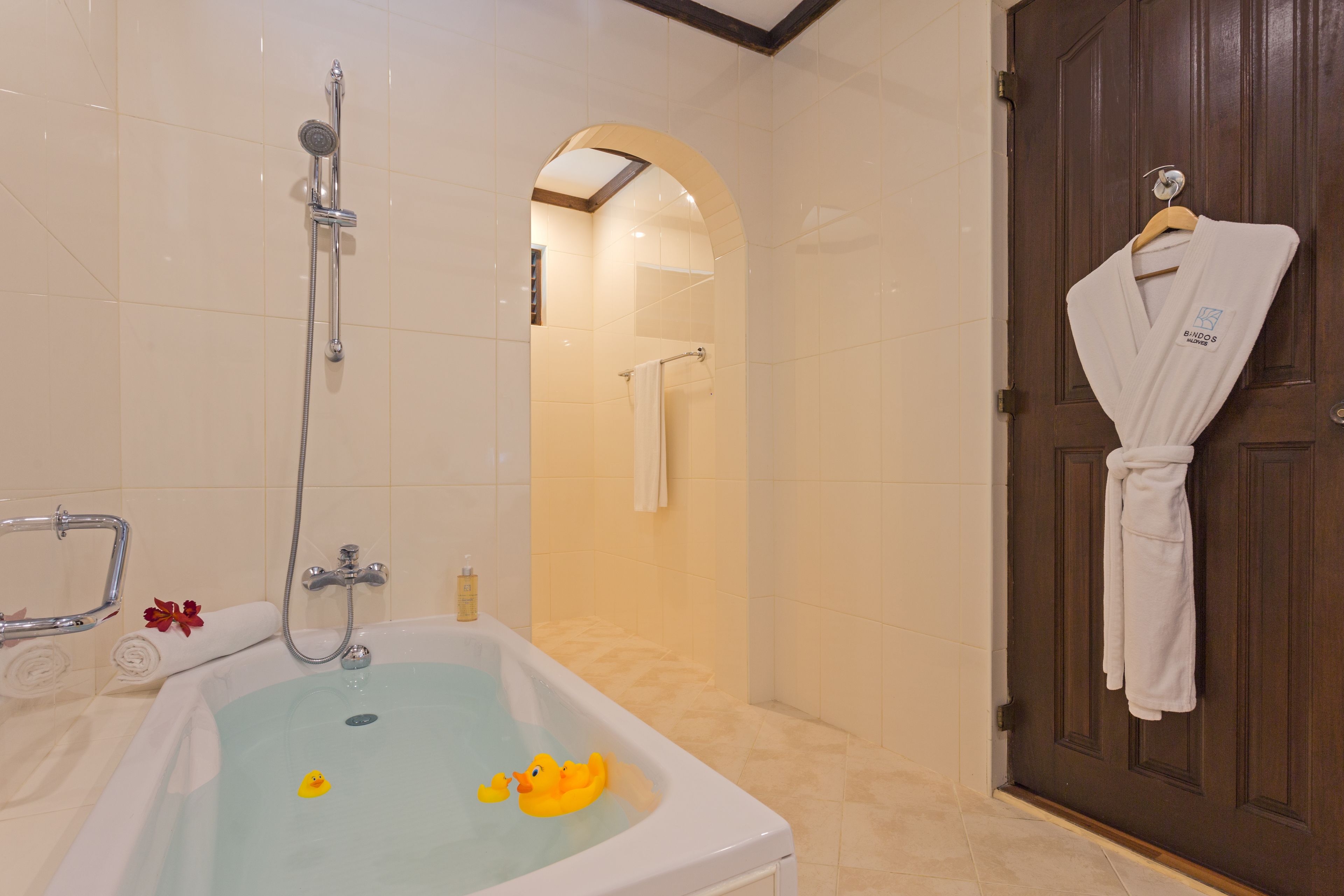 A bathroom with a bathtub, a shower, and a wooden door.