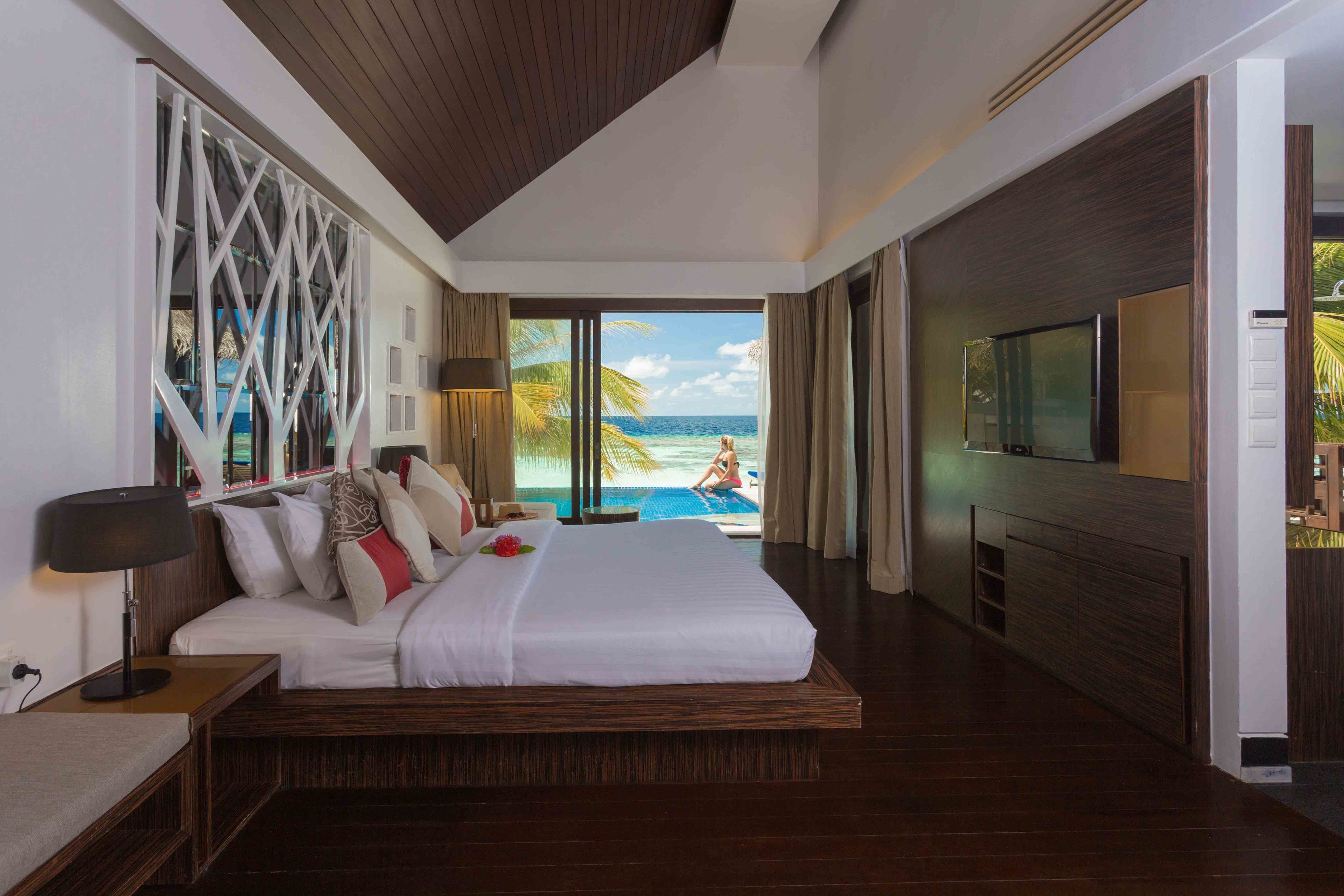 Habitació d'hotel moderna amb un llit gran, televisió i vistes a l'oceà.