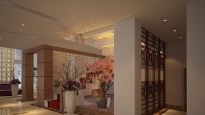 Un vestíbulo moderno con una pared decorativa, un mostrador de recepción y una zona de estar.