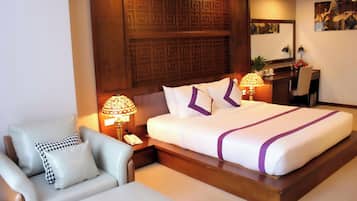 Una camera d'albergo con un letto grande, un divano, una scrivania e un pannello decorativo a parete.