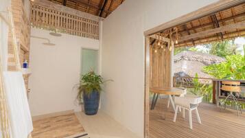 A bathroom with a shower, a sink, and a large potted plant.