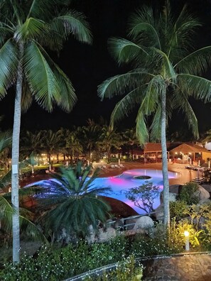 A nighttime view of a resort with a swimming pool, palm trees, and outdoor seating areas. -  Phu Hai Beach Resort & Spa Phan Thiet (Phan Thiet)