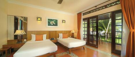 A hotel room with two beds, a ceiling fan, a large window with curtains, and a view of palm trees.