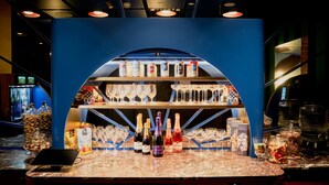 A bar area with shelves of bottles, glasses, and a laptop on the counter. - Laneways by Ovolo (Melbourne)
