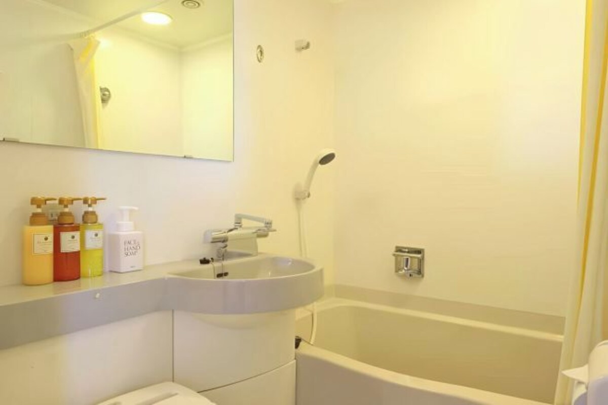 A bathroom with a sink, mirror, and shower.