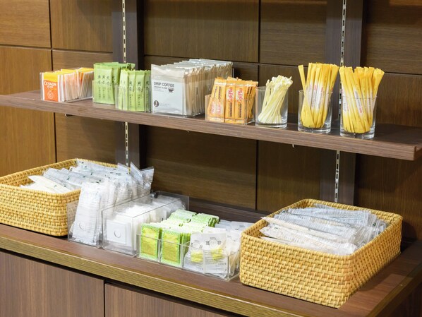 Une variété de produits à base de café était exposée, notamment du café filtre, du café instantané et des dosettes de café, présentés sur des étagères et dans des paniers.