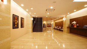 A spacious lobby with a marble floor, a reception desk, and framed artwork on the walls. - Chisun Hotel Hiroshima (Hiroshima)