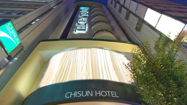 The Chisun Hotel's interior with a curved reception desk and a staircase leading to the upper floors. - Chisun Hotel Hiroshima (Hiroshima)