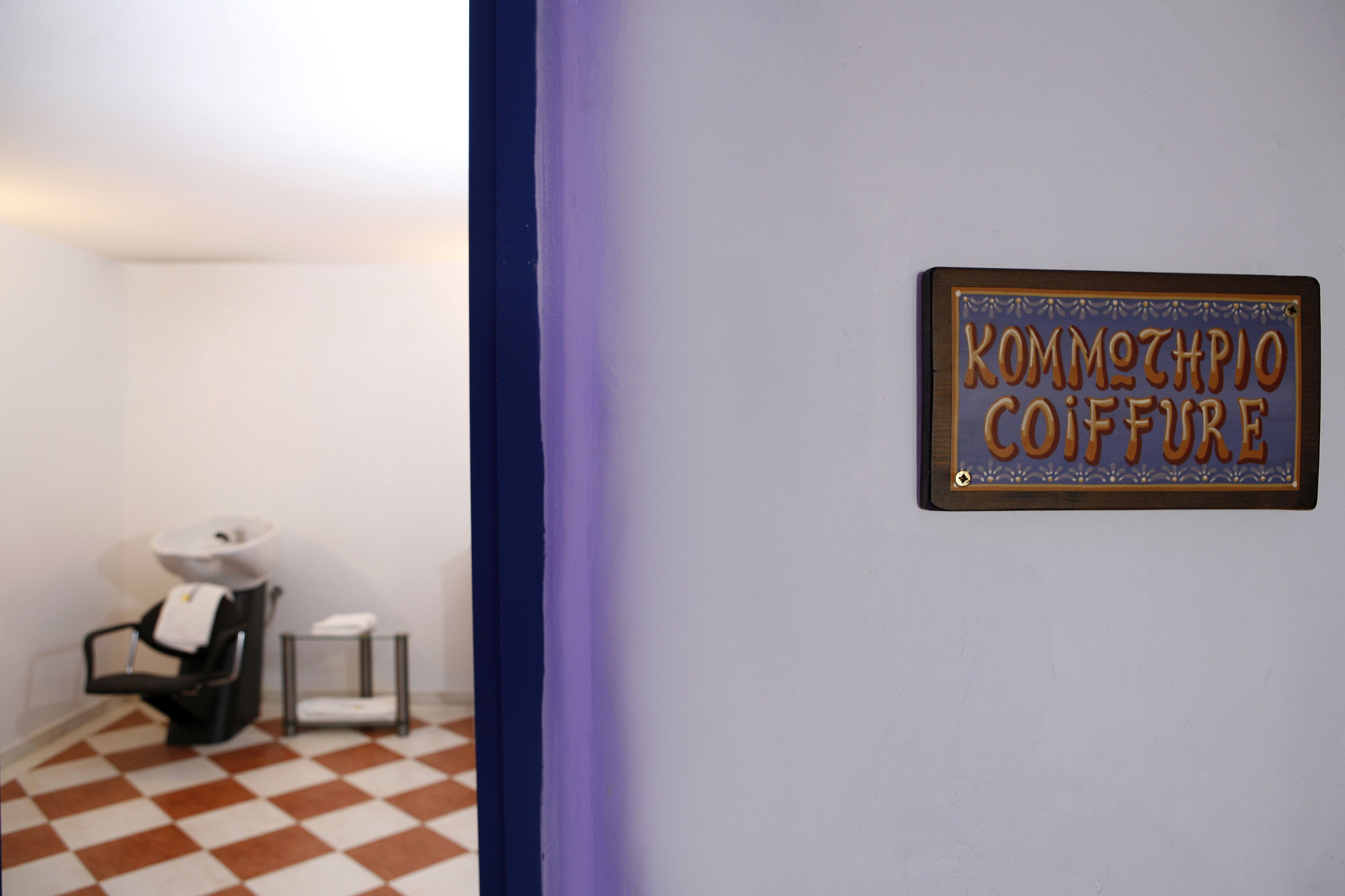A bathroom with a checkered floor, a sink, and a towel rack.