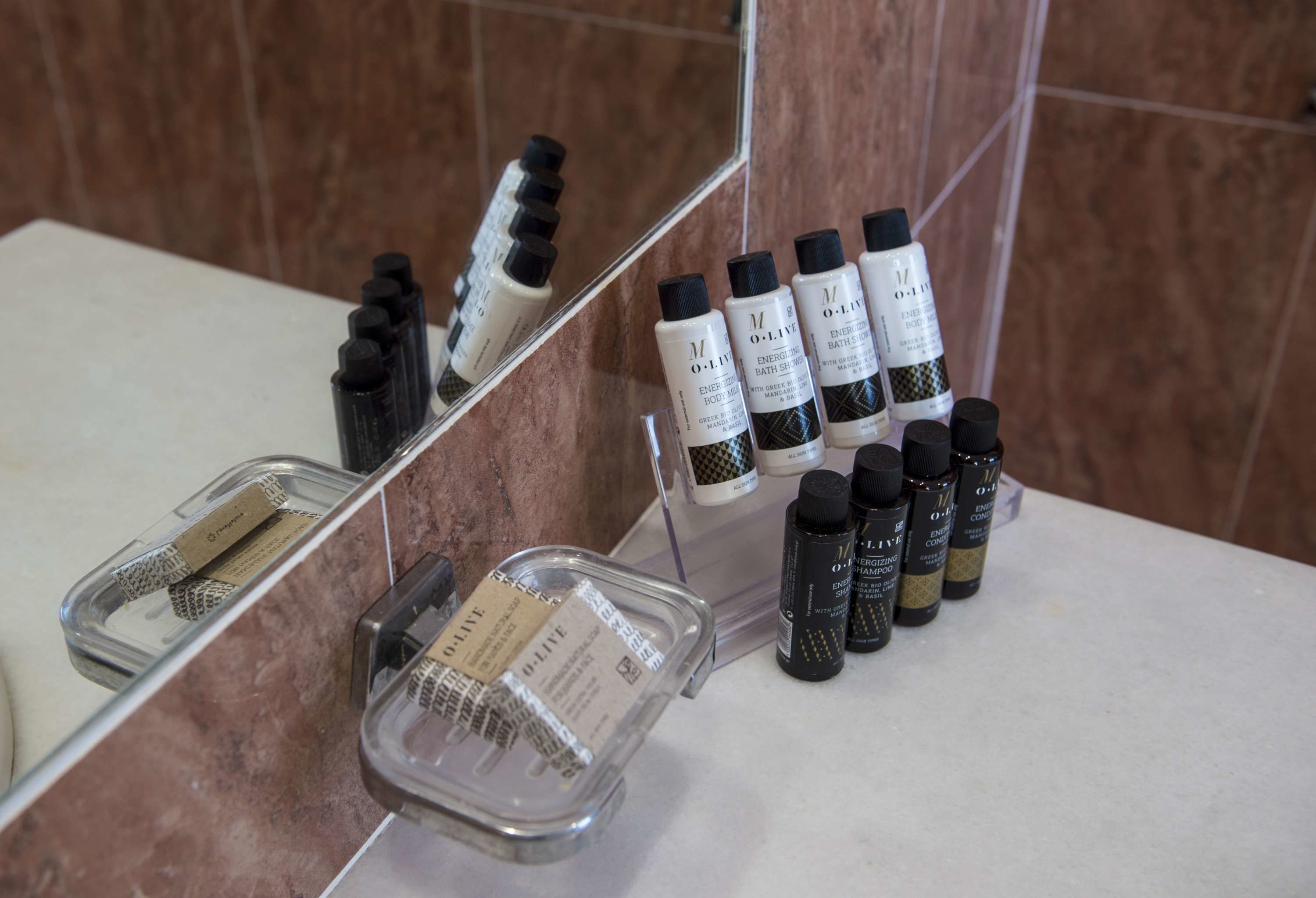 A bathroom counter with toiletries and a clear soap dish.