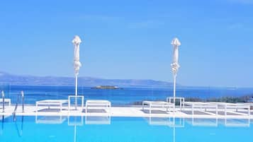 Piscine extérieure, parasols de plage, chaises longues