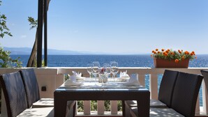 A dining table set with white tableware and glasses, overlooking the sea. - Hotel Kristal - Liburnia (Opatija)