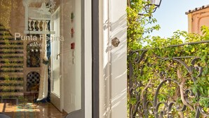 A hotel entrance with a reflective glass door, a metal gate, and a sign above the door.