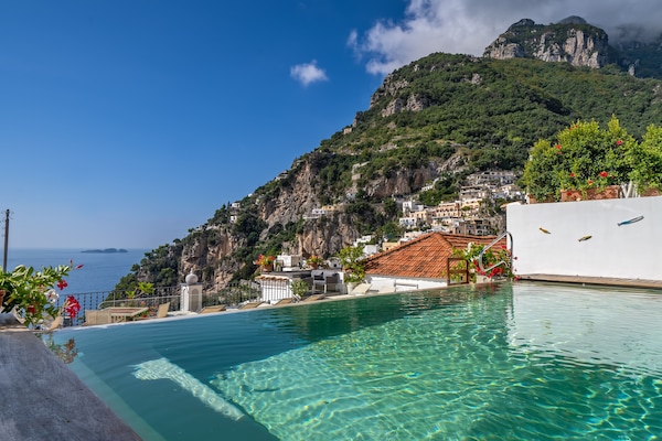 Una piscina al aire libre, sombrillas, tumbonas