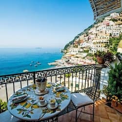 Enjoy a meal on the balcony with a view of the coastal town and the sea.