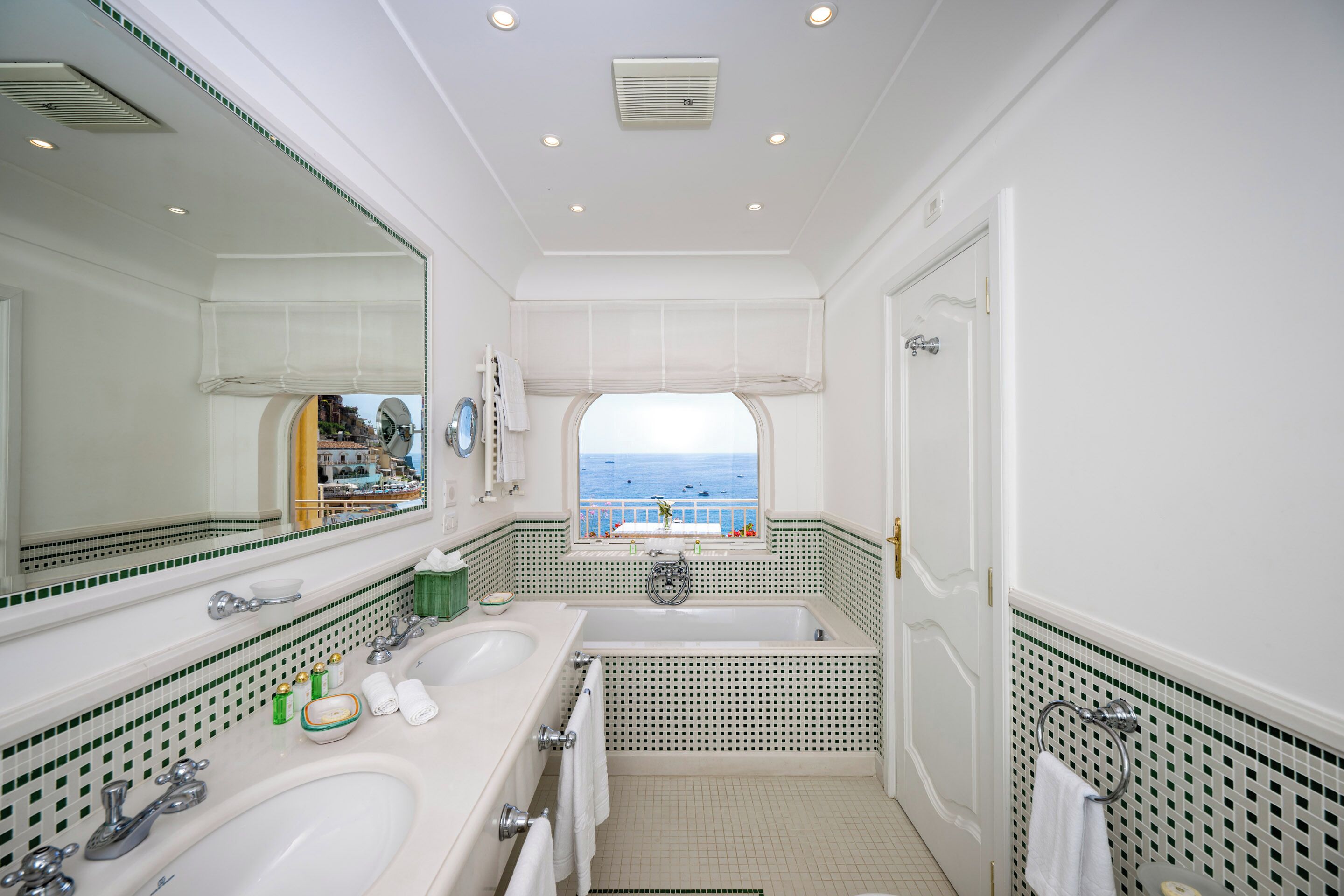 Un bagno con due lavandini, una vasca e un grande specchio.