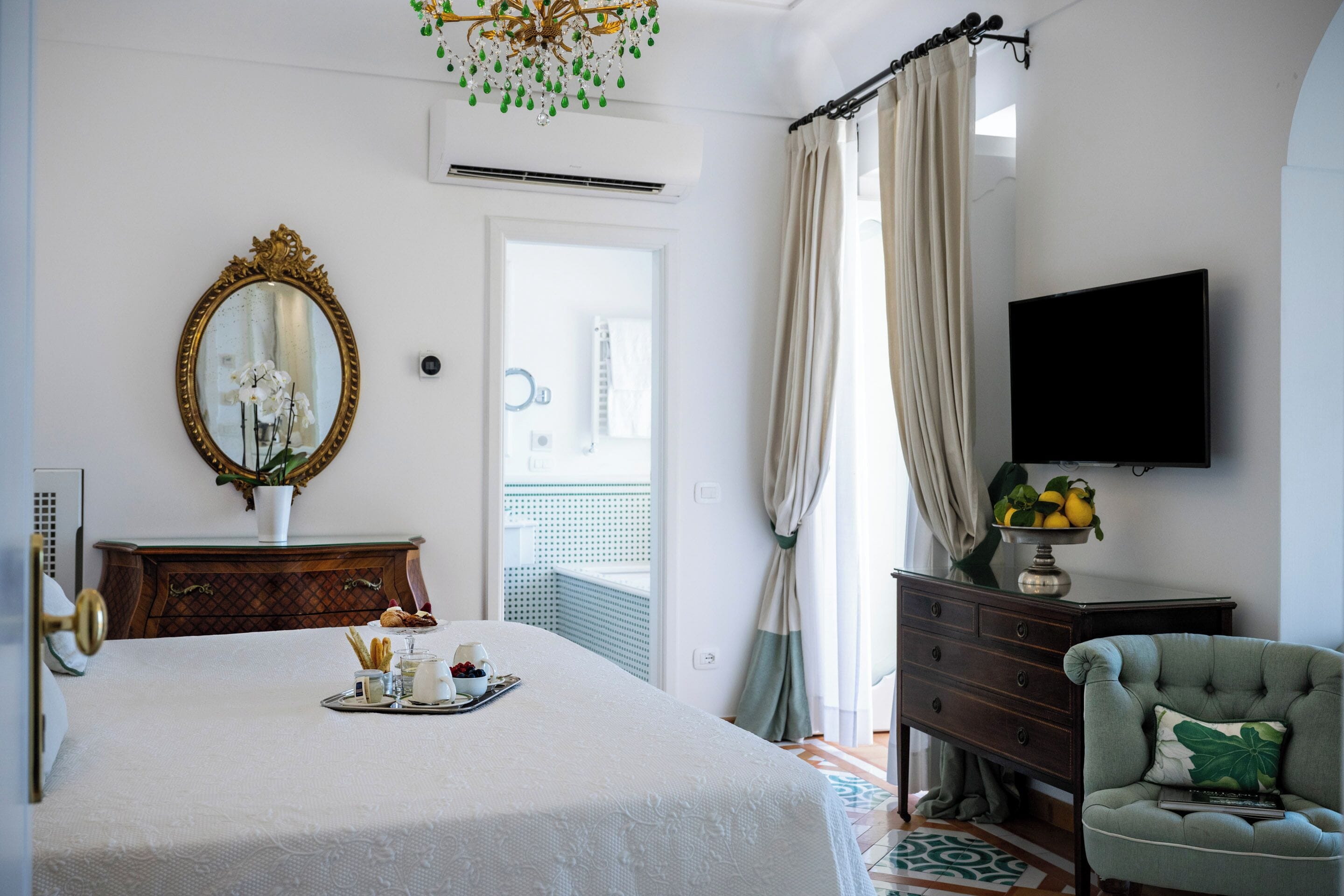 A bedroom with a bed, a dresser, a television, and a chair.