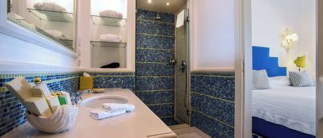 A bathroom with a sink, mirror, and glass shower enclosure.