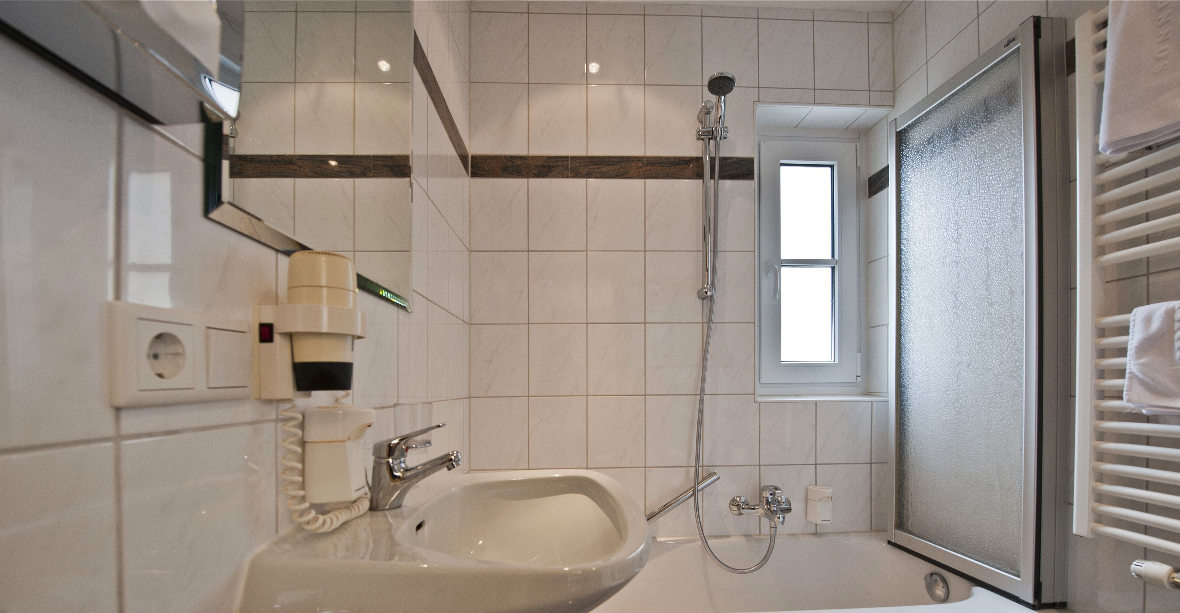 Une salle de bain moderne avec un lavabo, un miroir et une douche.
