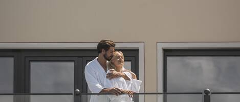 A couple embracing on a balcony with a mountain view.