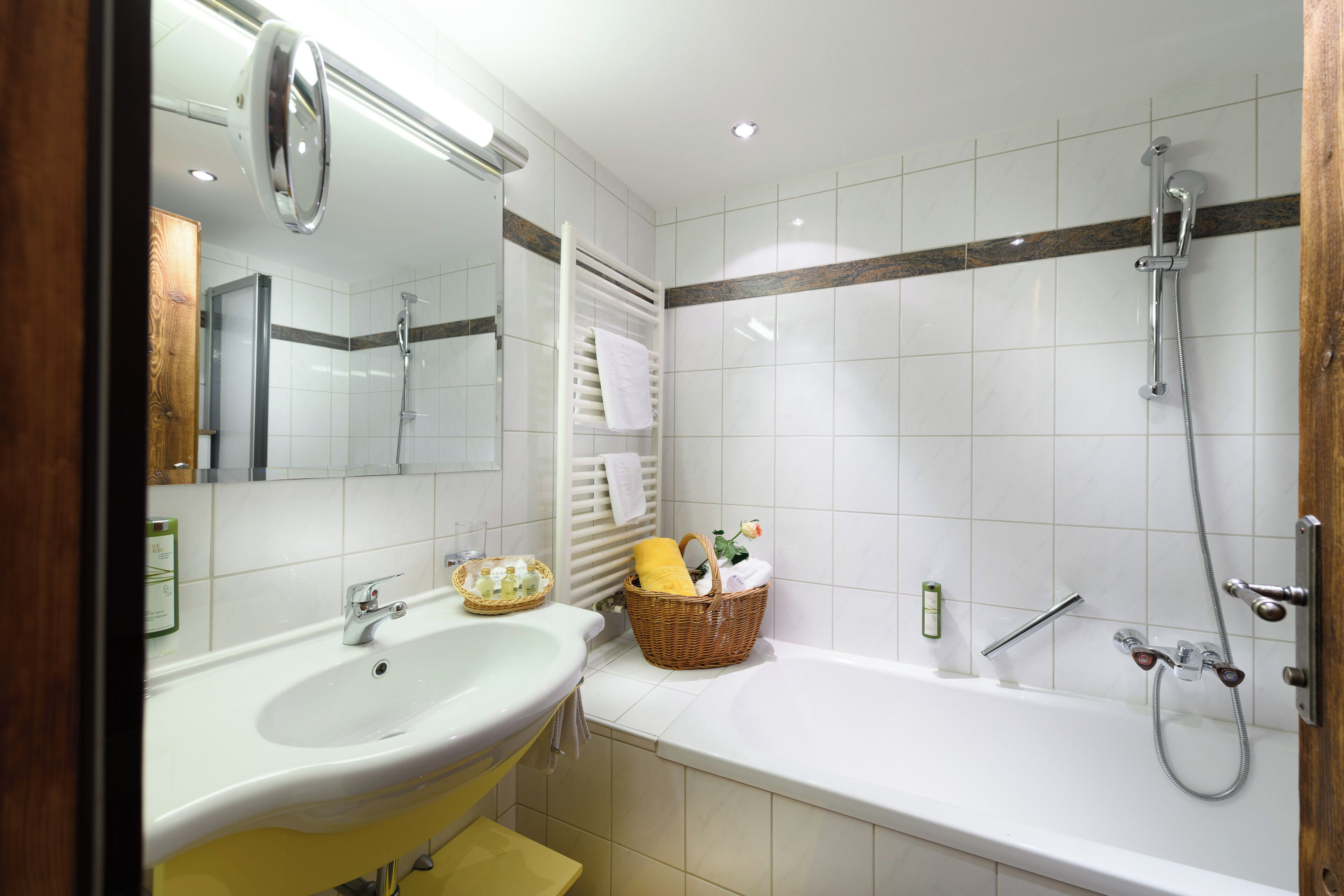 A bathroom with a sink, mirror, and shower.