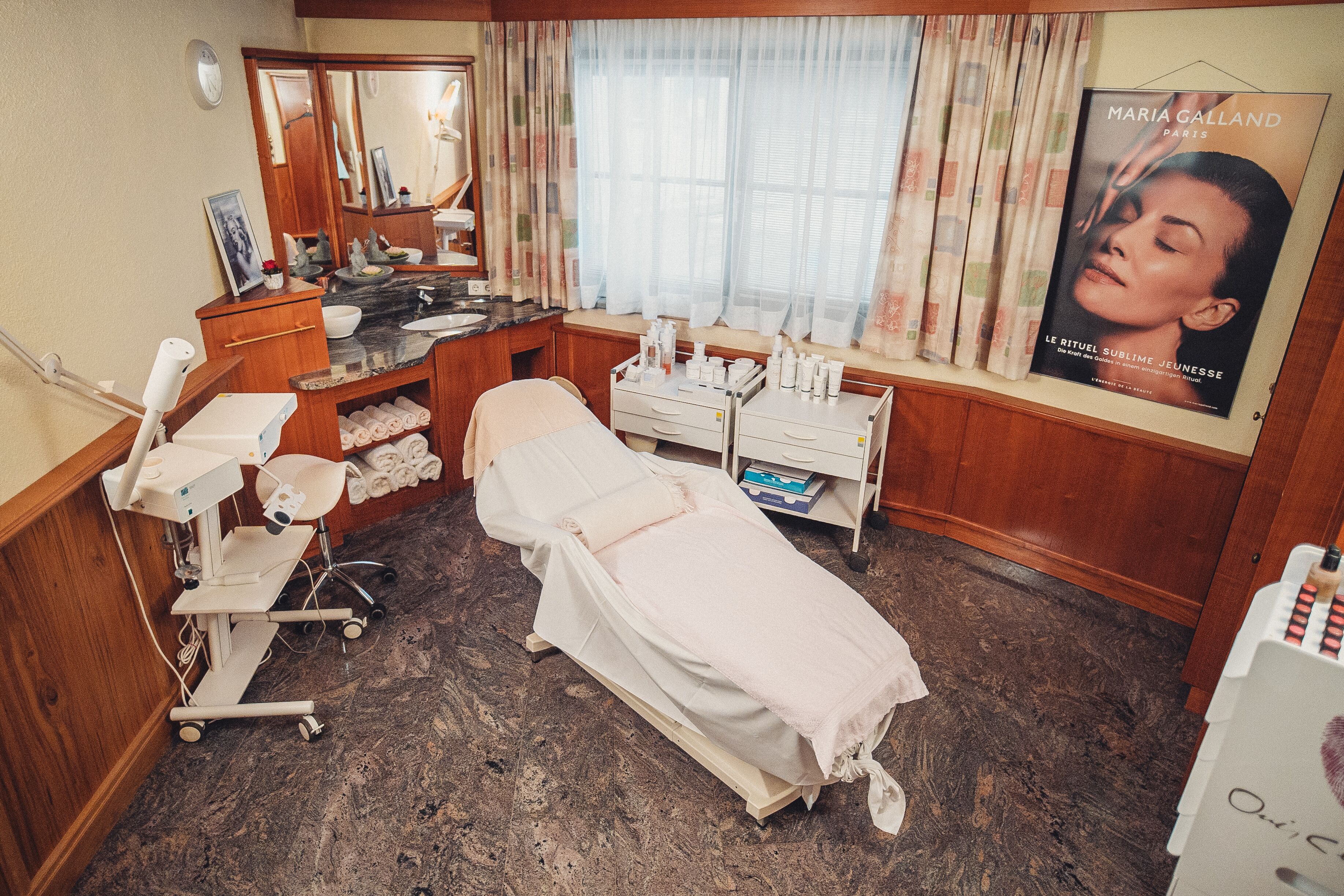 A medical examination room with a bed, examination table, and various medical equipment.