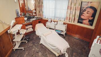 A medical examination room with a bed, examination table, and various medical equipment.