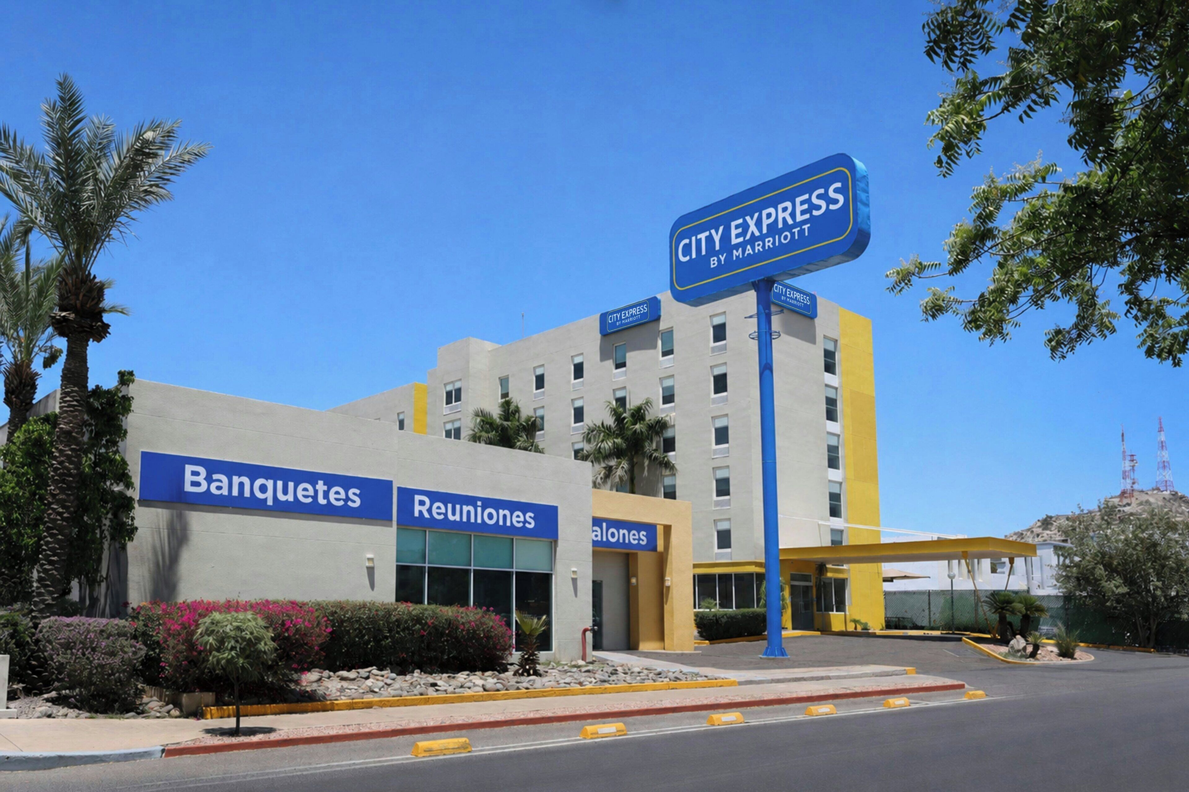 A hotel with a sign for City Express by Marriott, featuring Banquetes, Reuniones, and Salones.