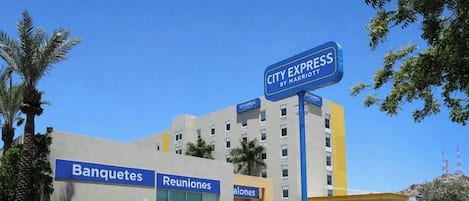 A hotel with a sign for City Express by Marriott, featuring Banquetes, Reuniones, and Salones.