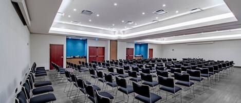 A conference room with rows of chairs, a podium, and blue accent walls.