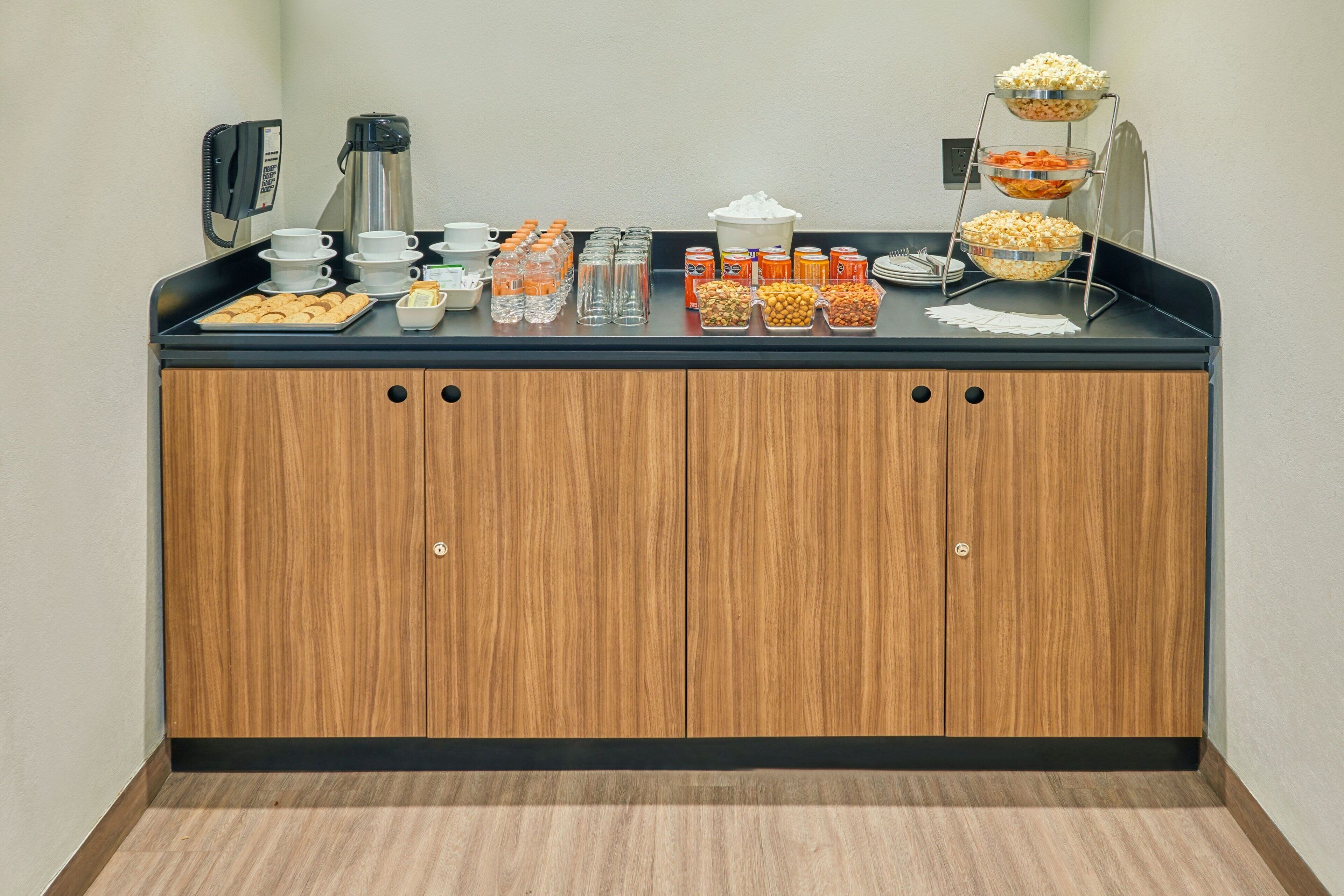 A buffet setup with various food items and beverages on a counter.