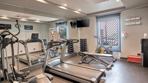 Un gimnasio con cintas de correr, elípticas y máquinas de pesas.