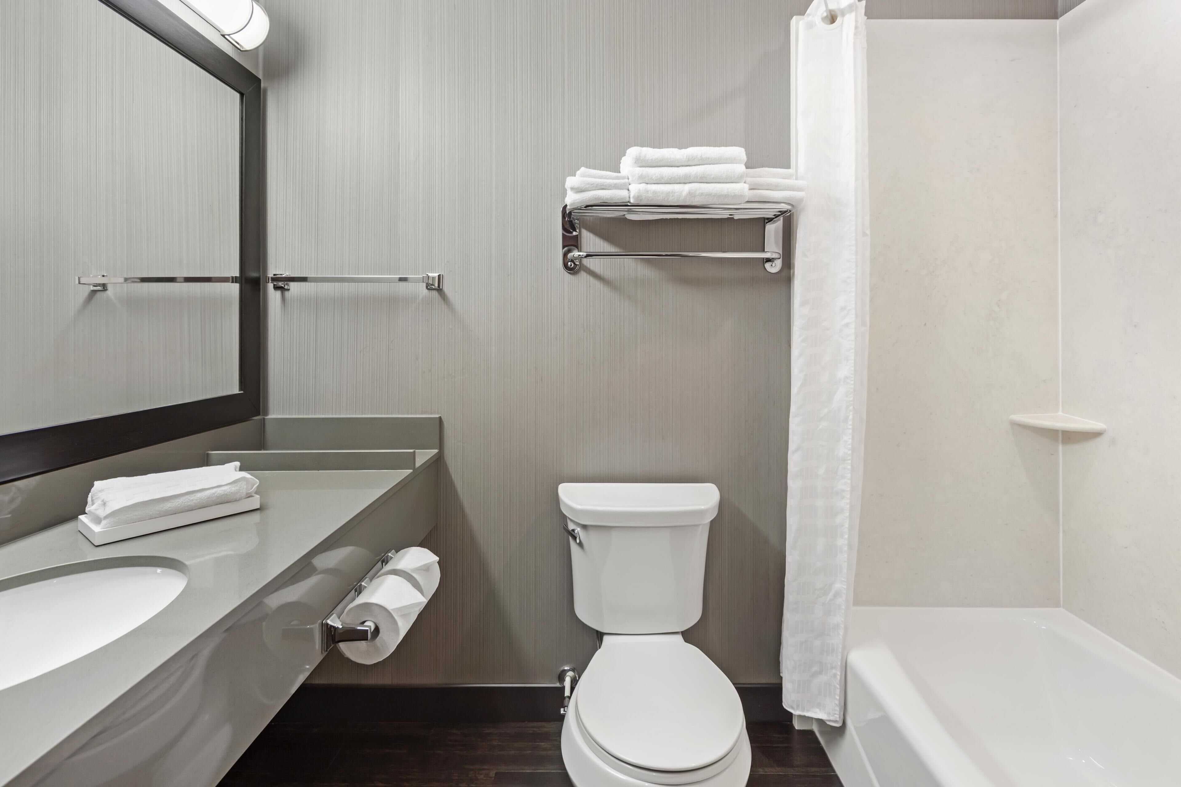 A modern bathroom with a toilet, sink, and bathtub.