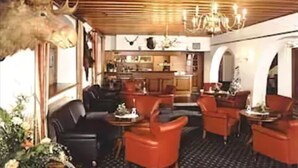 A restaurant with wooden ceiling, red chairs, and a moose head decoration. - Churfuerstliche Waldschaenke Moritzburg (Moritzburg)