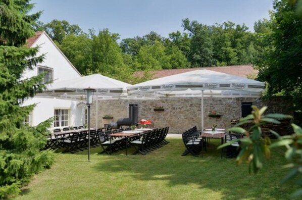 An outdoor patio area with stone walls and a covered seating area.