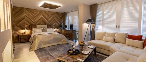 Un dormitorio moderno con una cama grande, un sofá, una mesa de centro y un escritorio.