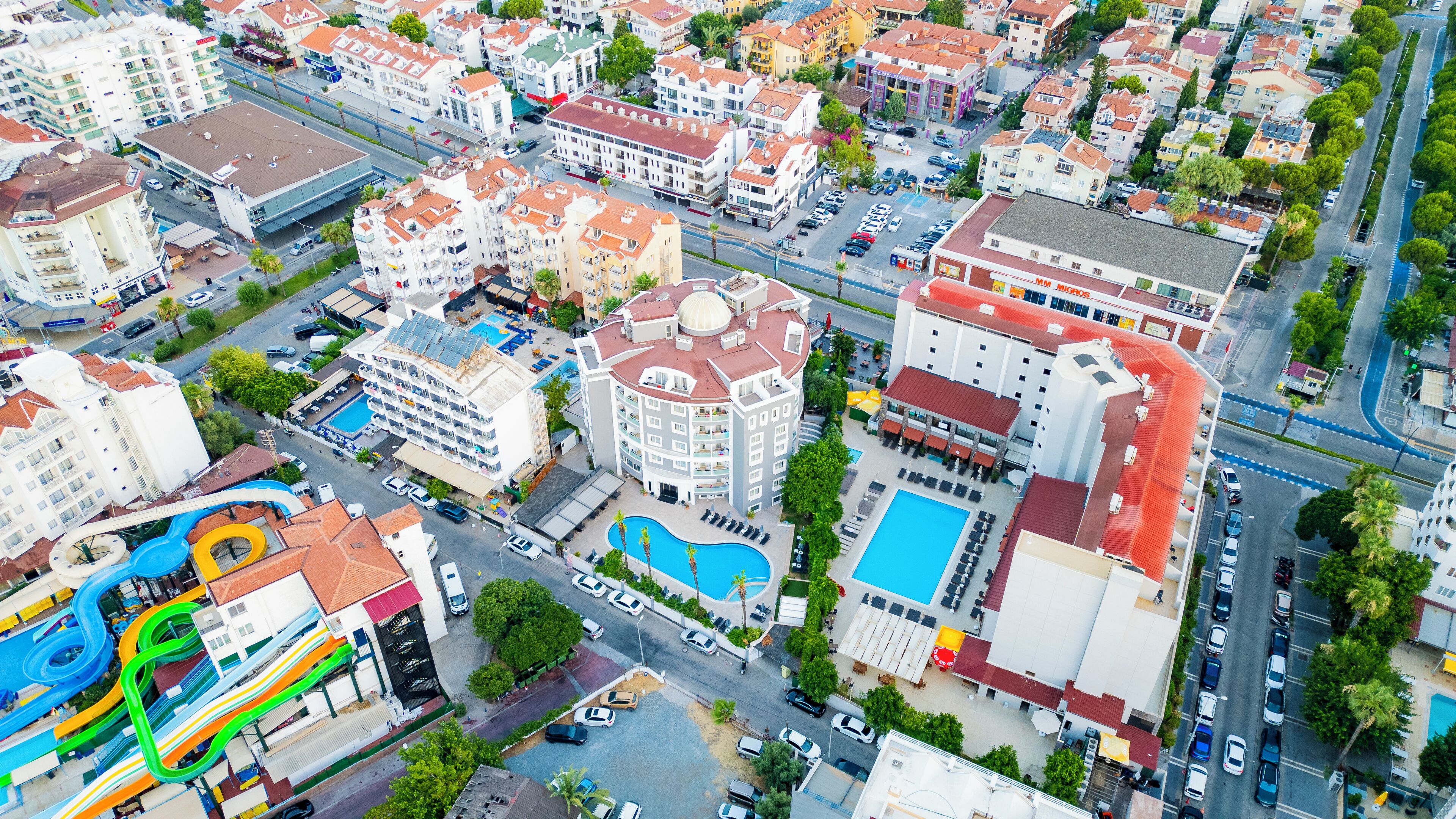 An aerial view of a hotel complex with multiple buildings, a swimming pool, and a water park.
