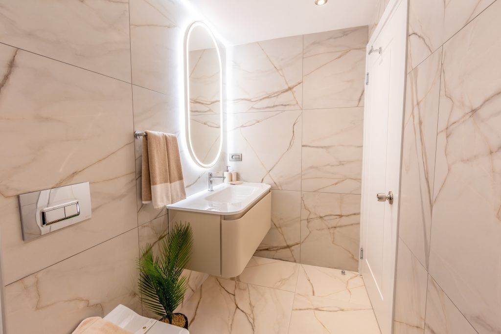 A modern bathroom with a marble floor, a vanity with a mirror, and a towel rack.