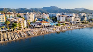 Un complejo turístico frente al mar con parque acuático, playa y edificios hoteleros.