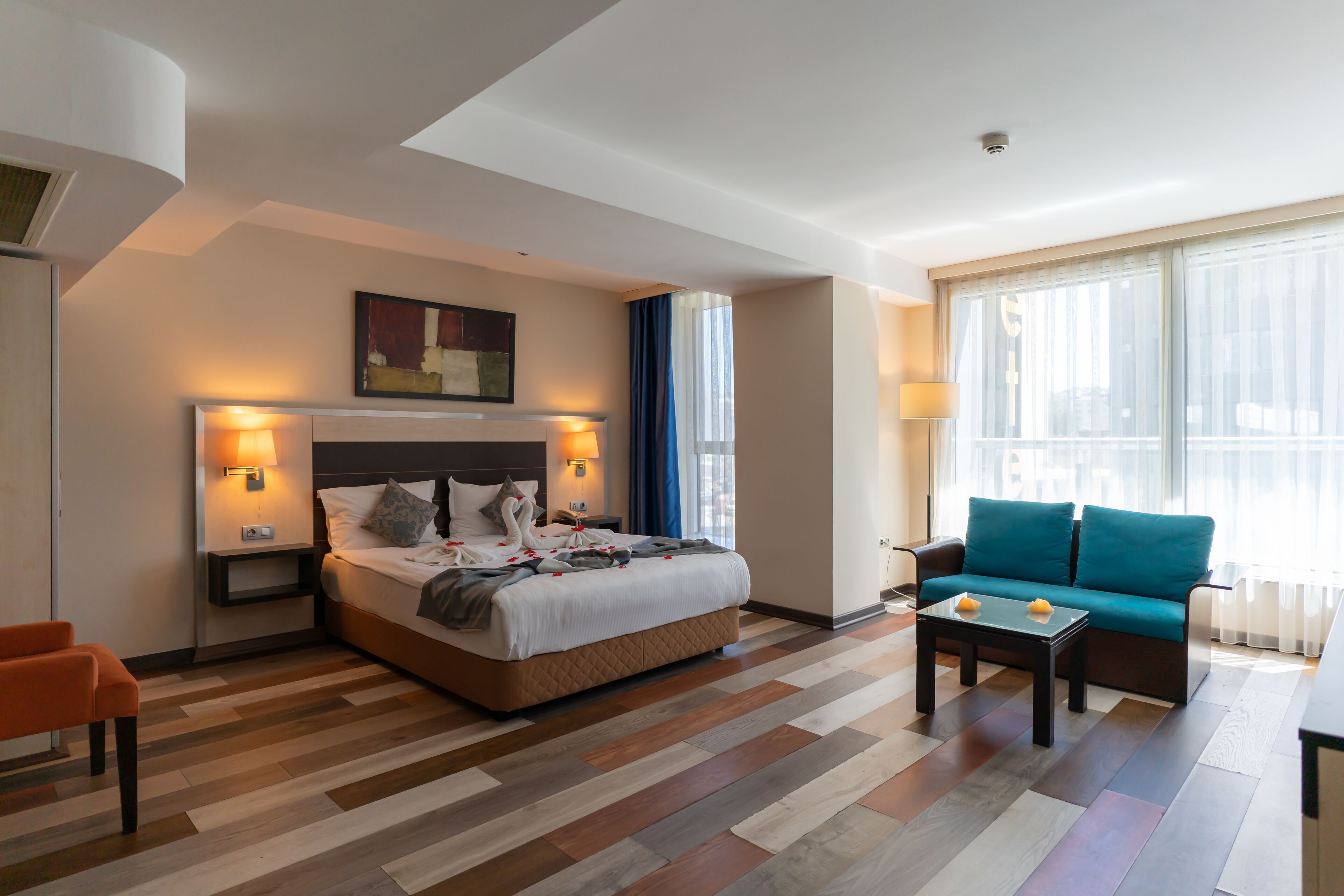 Una habitación de hotel con una cama, un sofá, una mesa de centro y una silla.