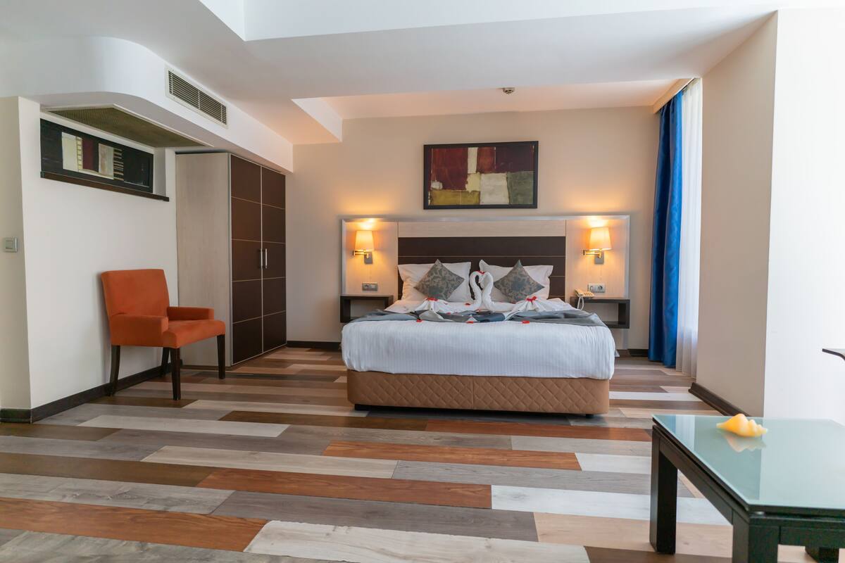 Une chambre d’hôtel avec un lit, une chaise, une table et un tableau au mur.