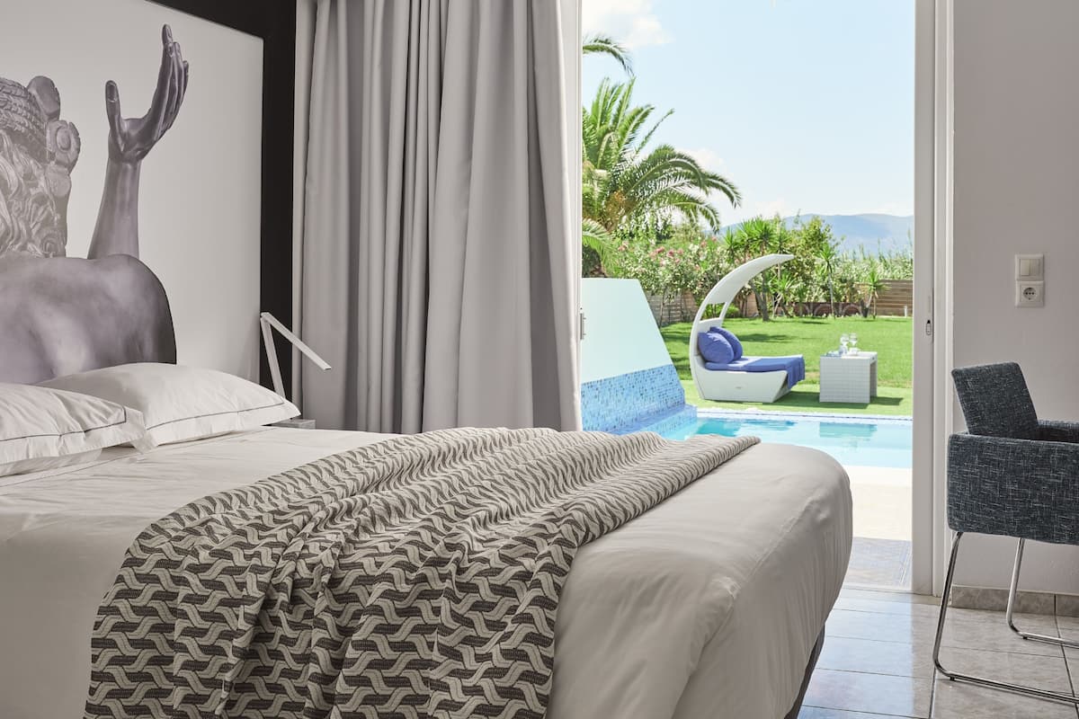 Un dormitorio con cama, vista a una piscina y una silla.