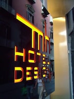 Segnaletica luminosa di un hotel con la scritta 'HOTEL DESIGN'.