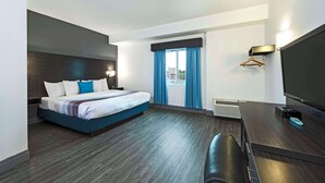 A modern hotel room with a large bed, a flat-screen TV, and a desk.