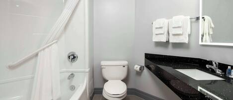 Uma casa de banho moderna com banheira, sanita e lavatório.