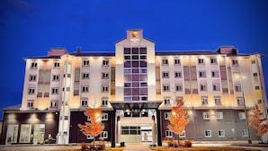A multi-story hotel with a central entrance, multiple balconies, and a prominent sign at the top.