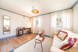 Una sala de estar con un sofá, una mesa de centro, una mesa de comedor y una silla.