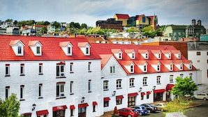 A white building with red roofs and multiple windows. - The Murray Premises Hotel (St. John's)
